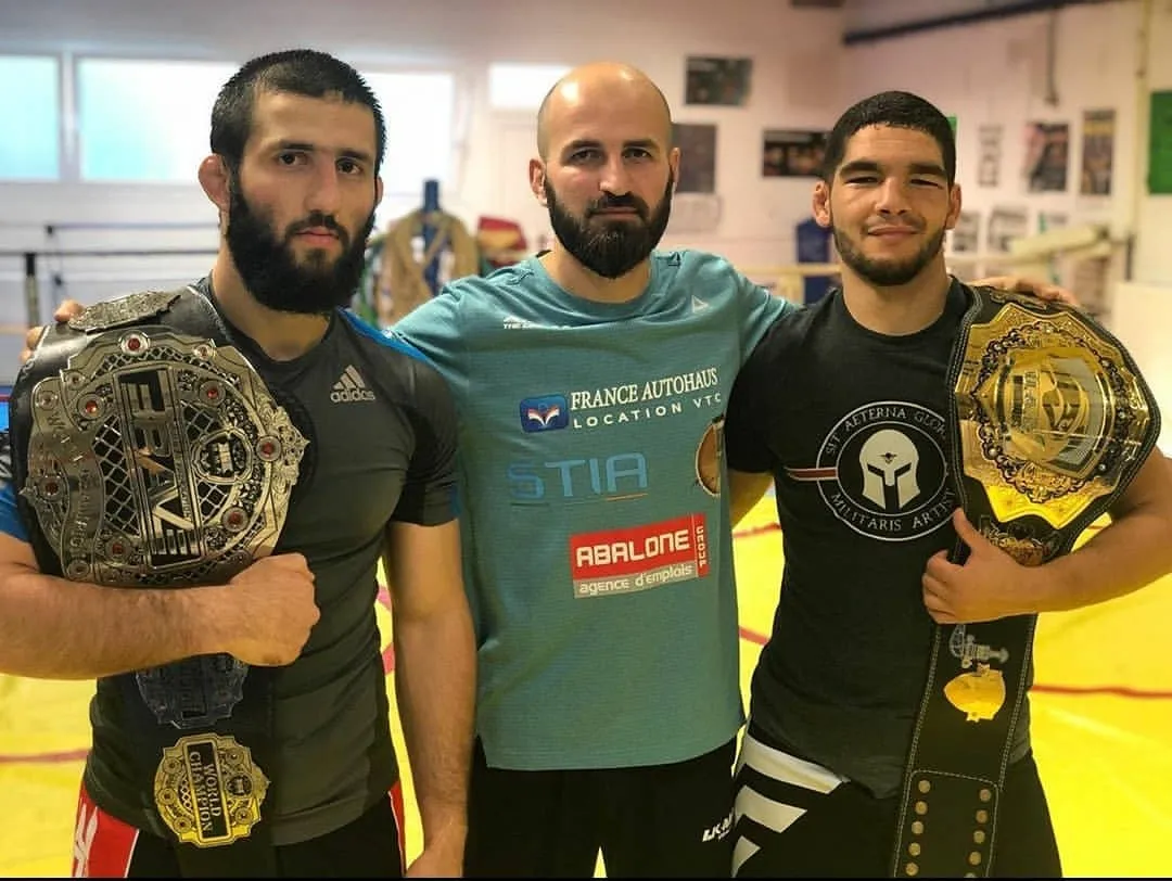 Trois membres de la team avec leurs ceintures de champion